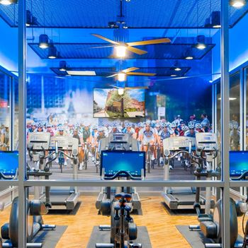 A fitness center featuring Peloton Cycle® Studio, Life Fitness machines, treadmills, and elliptical machines